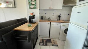 Una cocina compacta equipada con lavavajillas, cafetera y refrigerador.