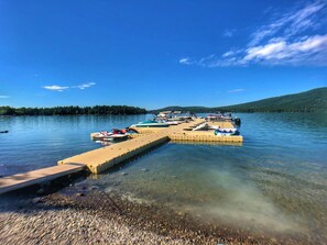 Une jetée s’avançant dans un lac, avec des bateaux amarrés à son extrémité.
