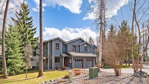 A two-story house with a gabled roof, a front porch, and a garage. - Lakefront Property- Newly Updated Four Bedroom House, Sleeps 10 (Whitefish)