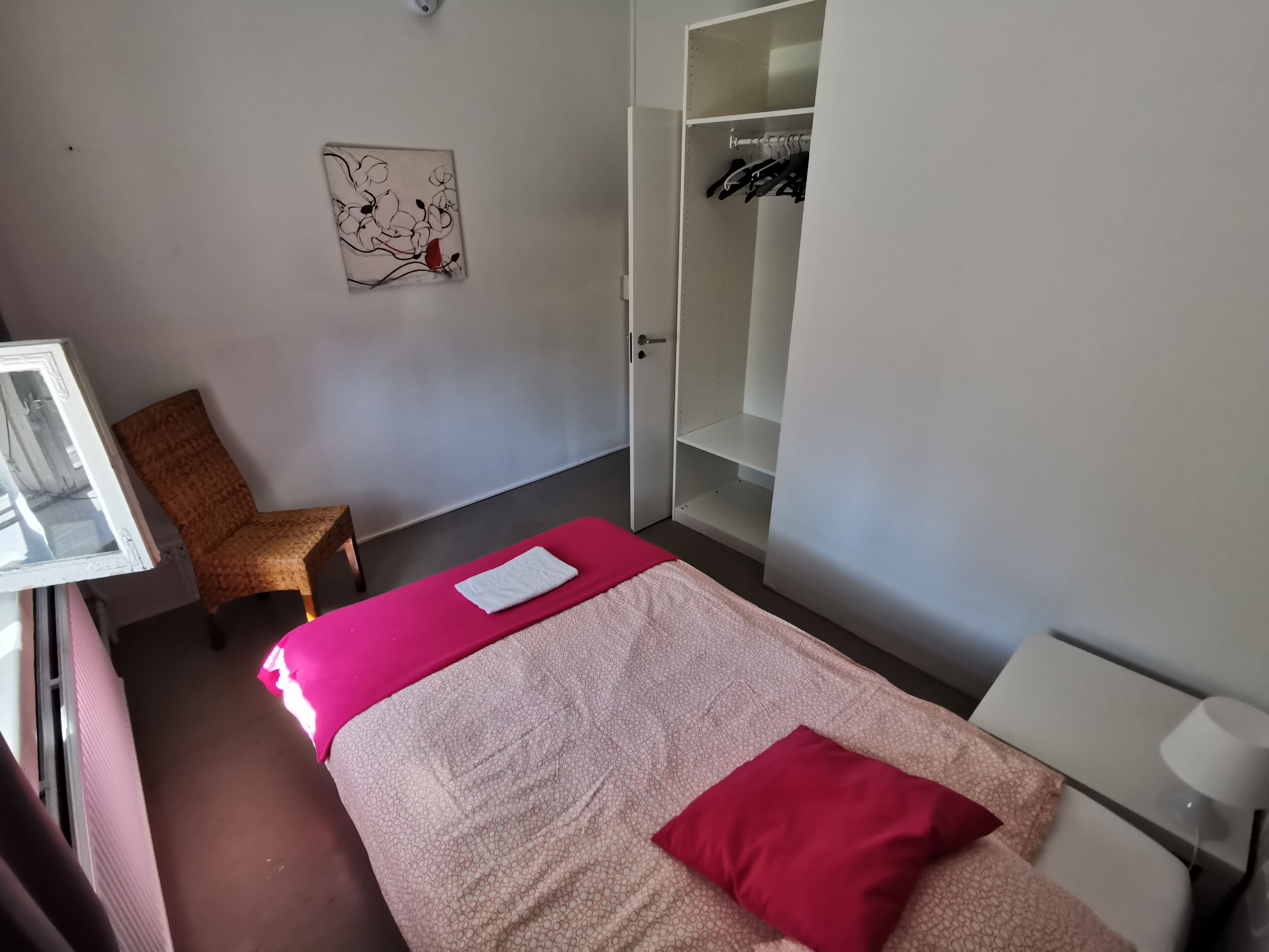 Une chambre à coucher comprenant un lit, une chaise, une armoire et une œuvre d’art murale.