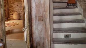 A rustic staircase with stone walls, a wooden door, and a lantern. - Maison de Village Atypique (Vidauban)