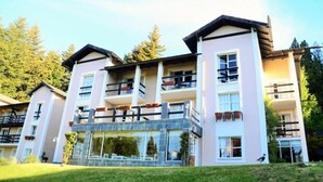 A multi-story hotel with balconies, large windows, and a stone facade.