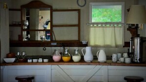A kitchen with a wooden countertop, a mirror, and various kitchen items. - Impeccable 2BR Condo w Spacious Balcony and Waterfront (San Carlos de Bariloche)