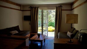Un salon confortable avec un canapé, une table basse, une lampe et un téléviseur.
