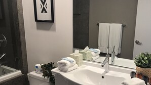 A modern bathroom with a toilet, sink, and bathtub. - Studio River & City View (Miami)