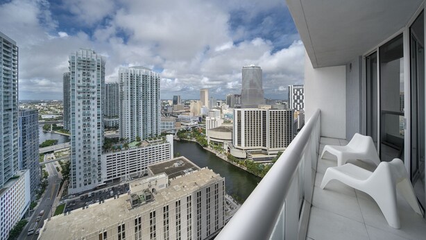 A high-rise building with a modern design, featuring a curved facade and a distinctive cylindrical section. - Studio River & City View (Miami)