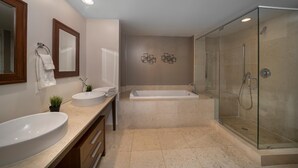 A modern bathroom with a large sink, a bathtub, and a glass-enclosed shower. - Presidential Ocean View (Miami)