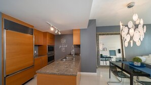 Eine moderne Küche mit Holzschränken, einer Granit-Arbeitsplatte und einem eingebauten Backofen.