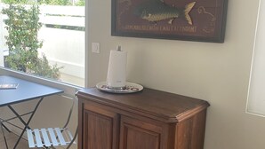 Een kamer met een houten kast, een tafel met een papieren handdoekdispenser, en een bord dat The Anglers Arms adverteert.