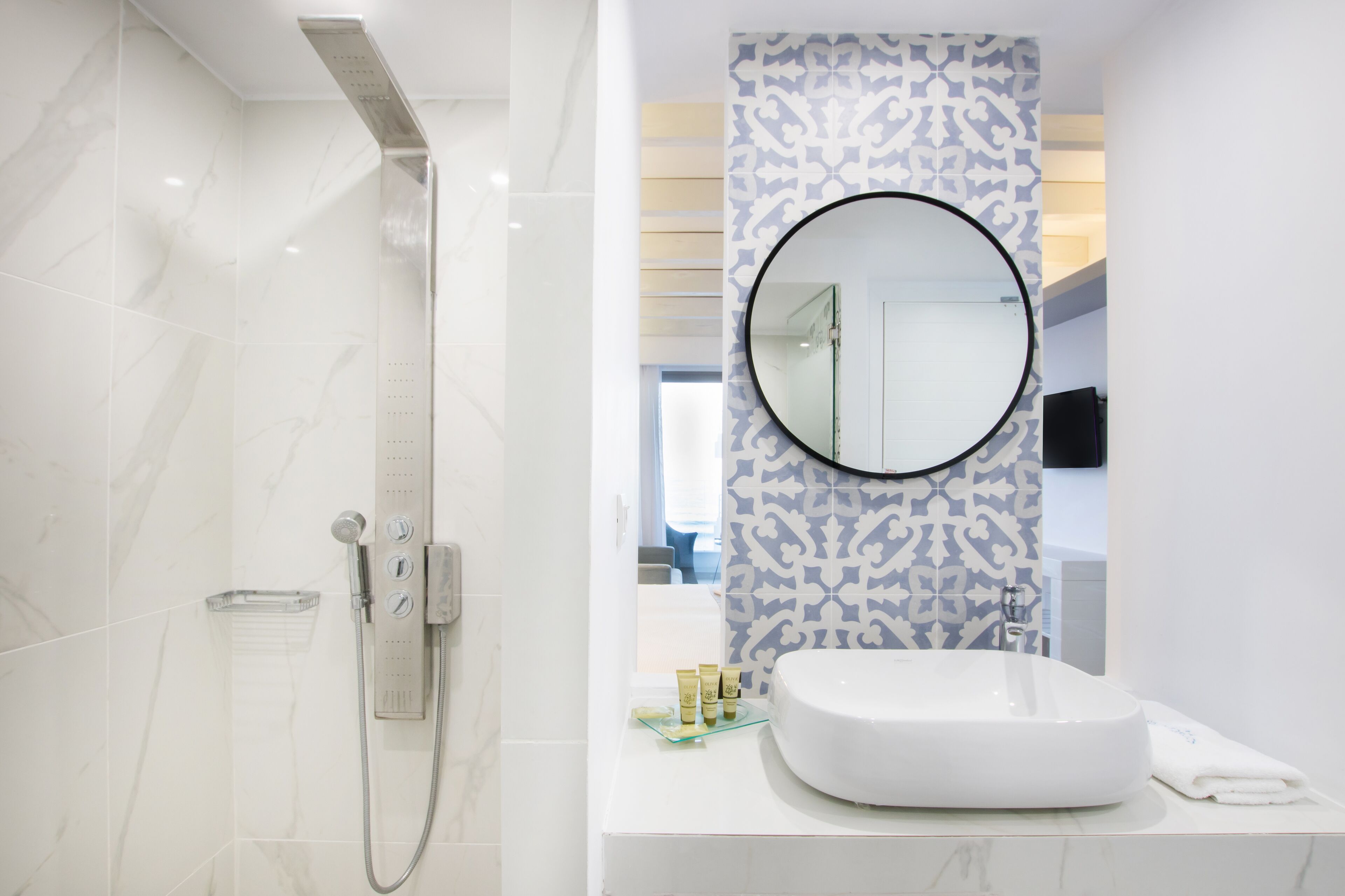 A modern bathroom with a shower, a sink, and a mirror.