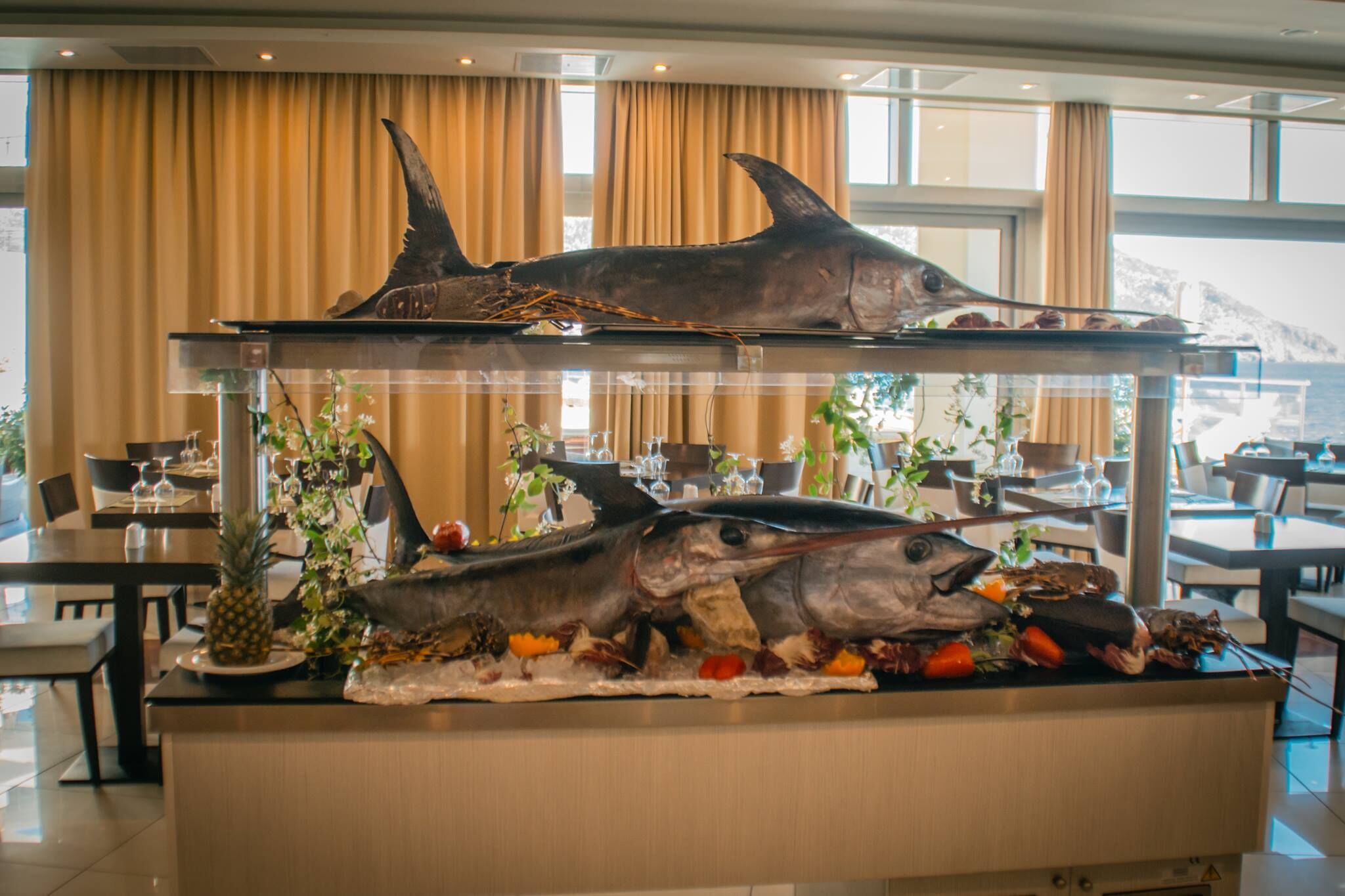 A seafood display with fish and tropical fruits in a hotel dining area.