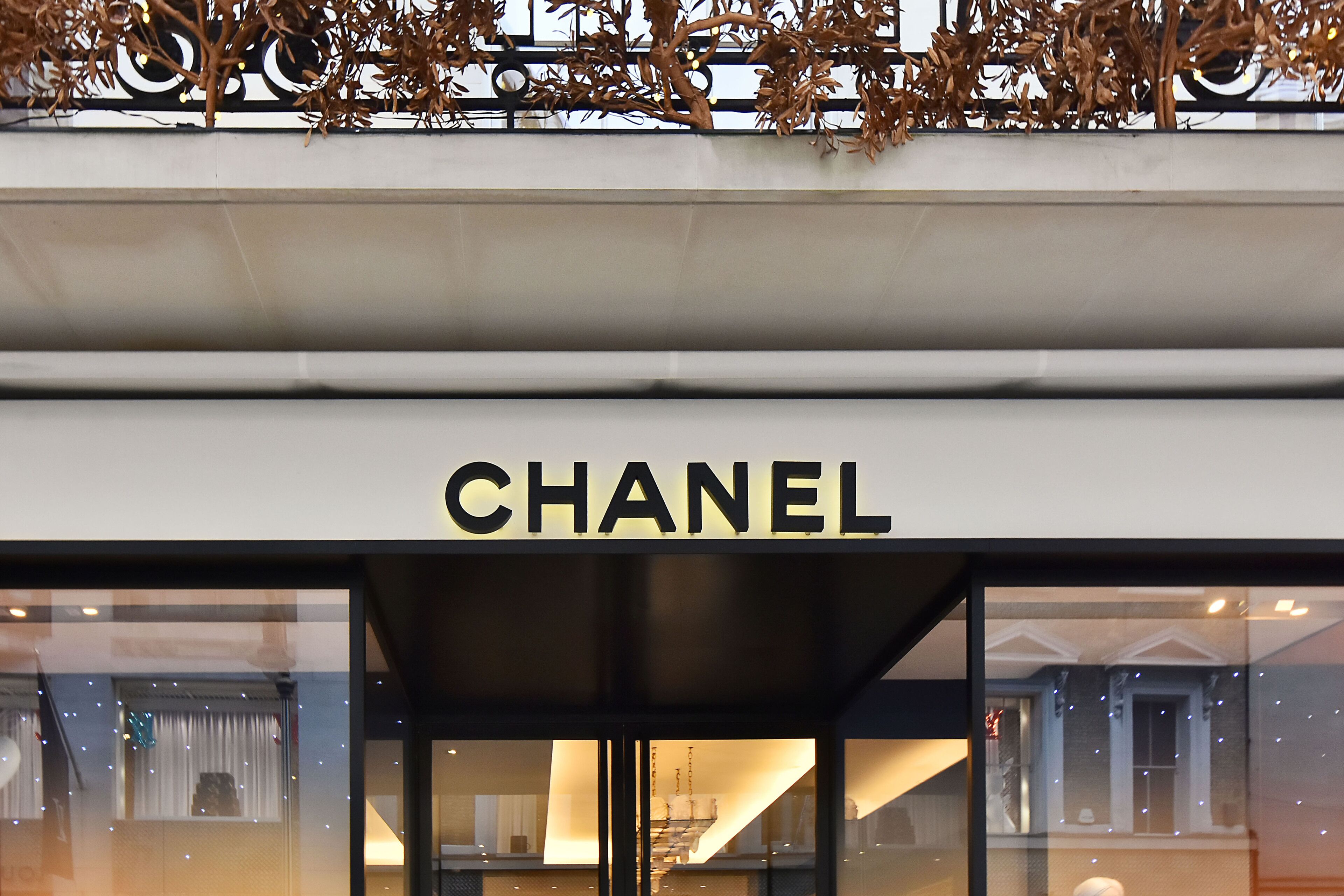 The exterior of a Chanel store with a prominent sign.
