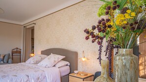A bedroom with a bed, bedside table, lamp, and a vase with flowers. - Independent apartment of two bedrooms of high standing and comfort. (Salernes)