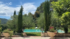 A pool surrounded by tall trees and a clear sky. - Independent apartment of two bedrooms of high standing and comfort. (Salernes)