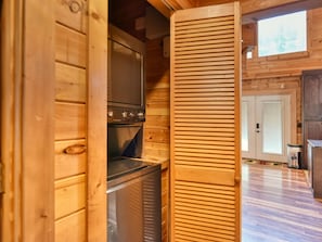 A wooden interior with a kitchen area featuring a stove and a refrigerator.