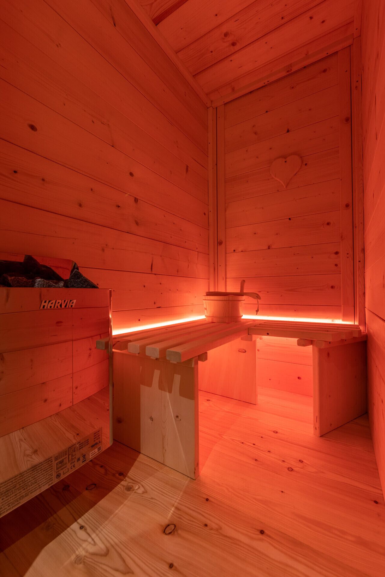 Een sauna met houten wanden en een bank.