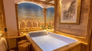 Ein Badezimmer im Holzblockhaus-Stil mit einer großen Badewanne, einer Holzbank und einem Wandgemälde einer Berglandschaft.