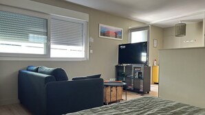 A modern living room with a sofa, a television, and a bed. - Studio Bordeaux 2 (Bordeaux)