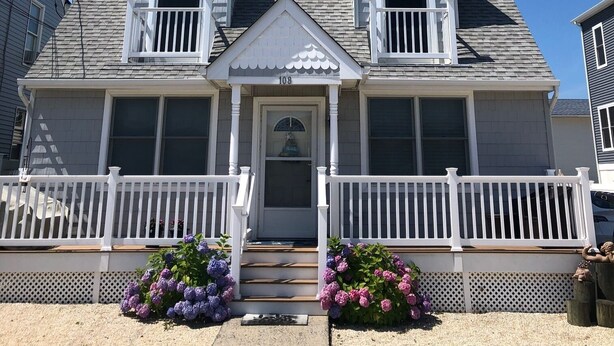 A two-story house with a front porch, a central door, and a small balcony. - Adorable 2BR Condo on Long Beach Island LBI  in Ship Bottom. Beach Block! (Ship Bottom)