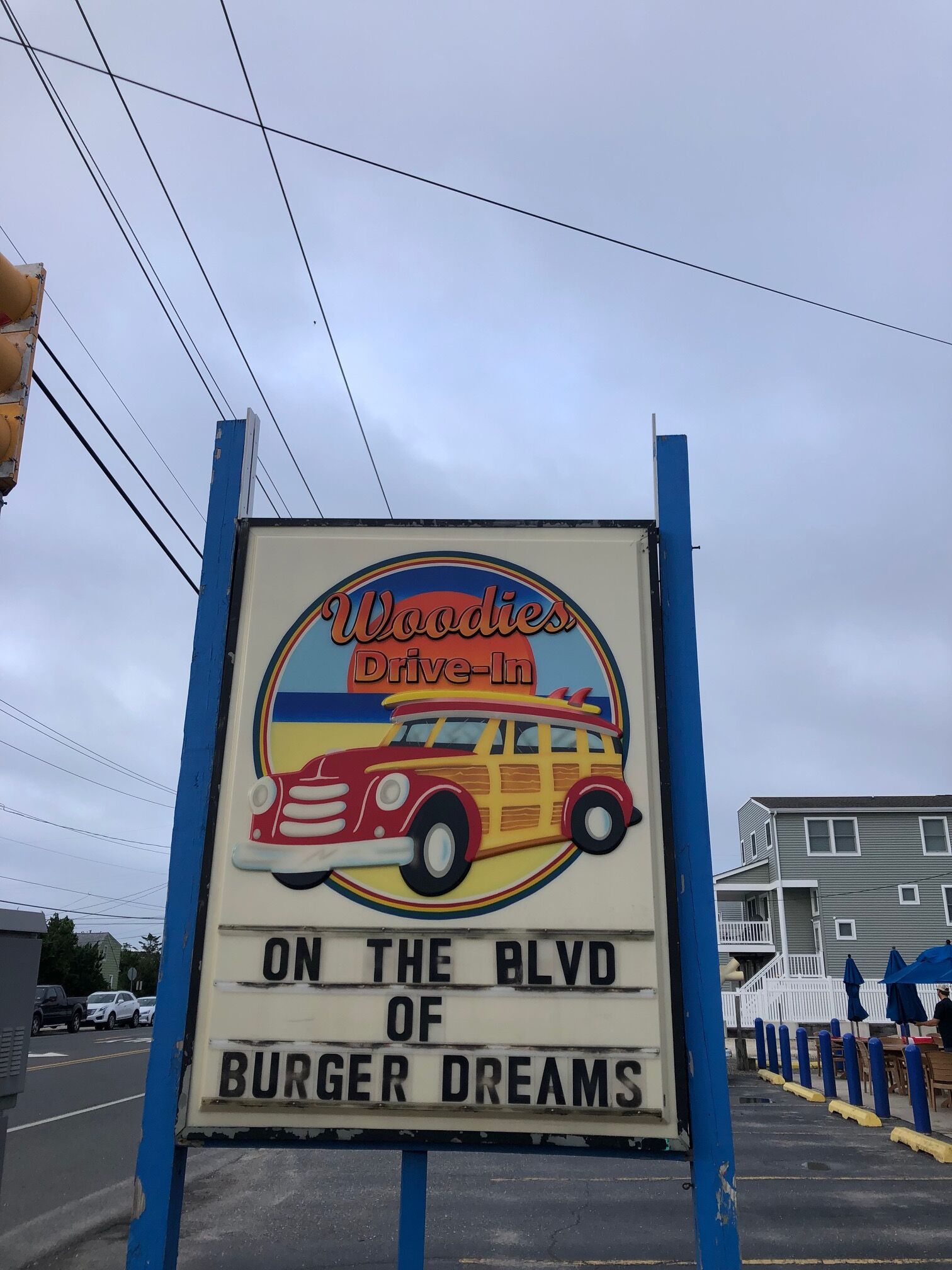 A sign for 'Woody's Drive-In' on the Boulevard of Burger Dreams.