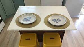 A table with two plates and two yellow stools. - Adorable 2BR Condo on Long Beach Island LBI  in Ship Bottom. Beach Block! (Ship Bottom)