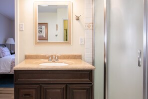 A bathroom with a sink, mirror, and cabinets.