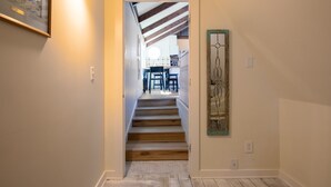 A hallway with a staircase leading to a dining area.