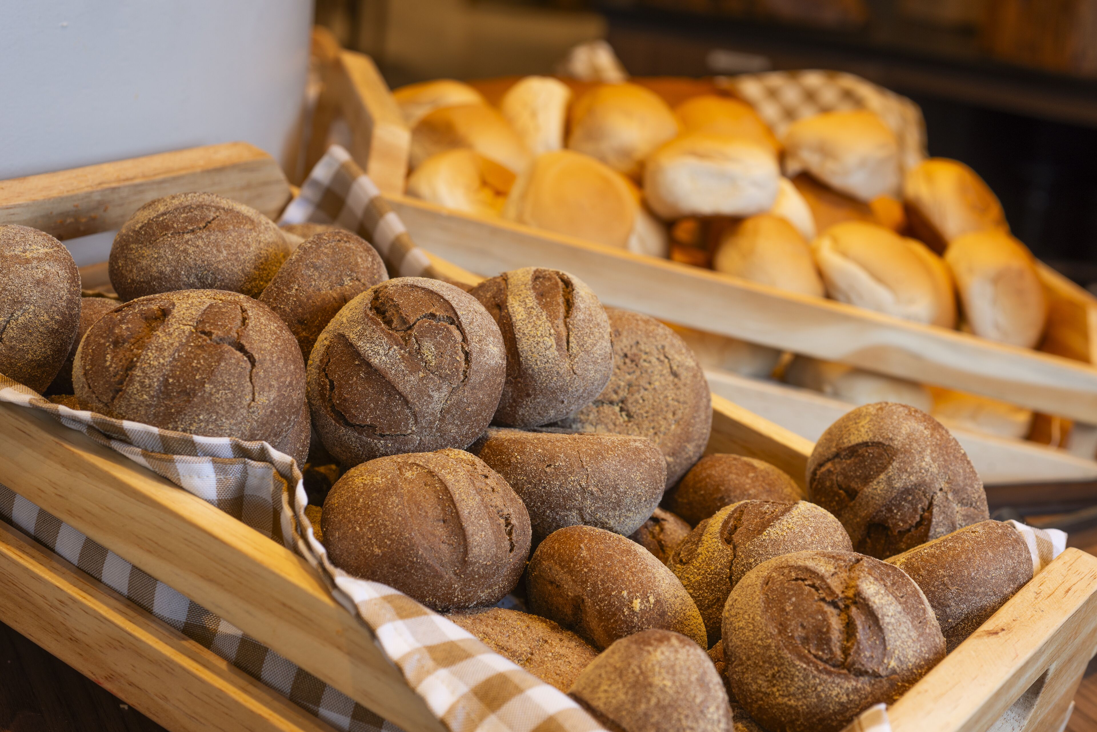 A display of various breads in wooden baskets.