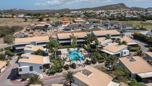 Una zona residencial con casas modernas, una piscina y un paisaje montañoso al fondo.