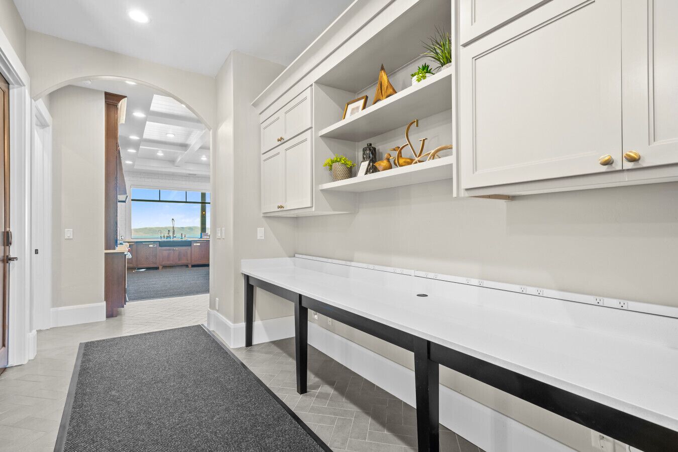 Una cocina moderna con armarios blancos, una encimera amplia y vistas al área exterior.