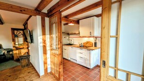 A kitchen with white cabinets, a wooden countertop, and a tiled floor. - Ferienwohnung auf Einem Resthof (Quickborn)