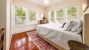 A bedroom with a bed, a ceiling fan, and large windows with blinds. - 6 Bedrooms in #1 Central Location (Austin)