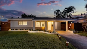 A modern two-story house with a well-maintained lawn and a driveway leading to the garage. - !! Modern & Stylish Fort Lauderdale Getaway !! (Fort Lauderdale)