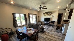 Un amplio salón con una mesa de comedor, sofás y una televisión.
