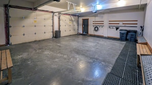 A spacious garage with a concrete floor, metal storage cabinets, and a door leading to another room.