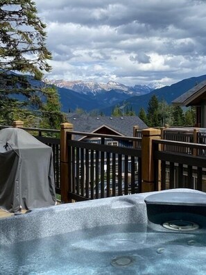 Un jacuzzi en una terraza con vistas a las montañas.