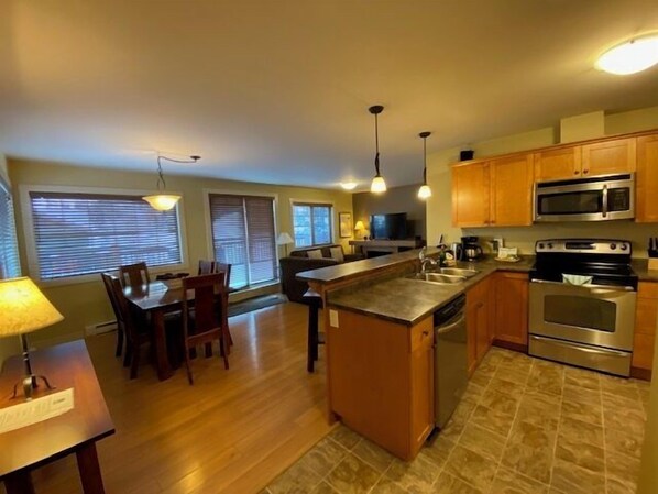 Una cocina moderna con armarios de madera, electrodomésticos de acero inoxidable y una isla central.