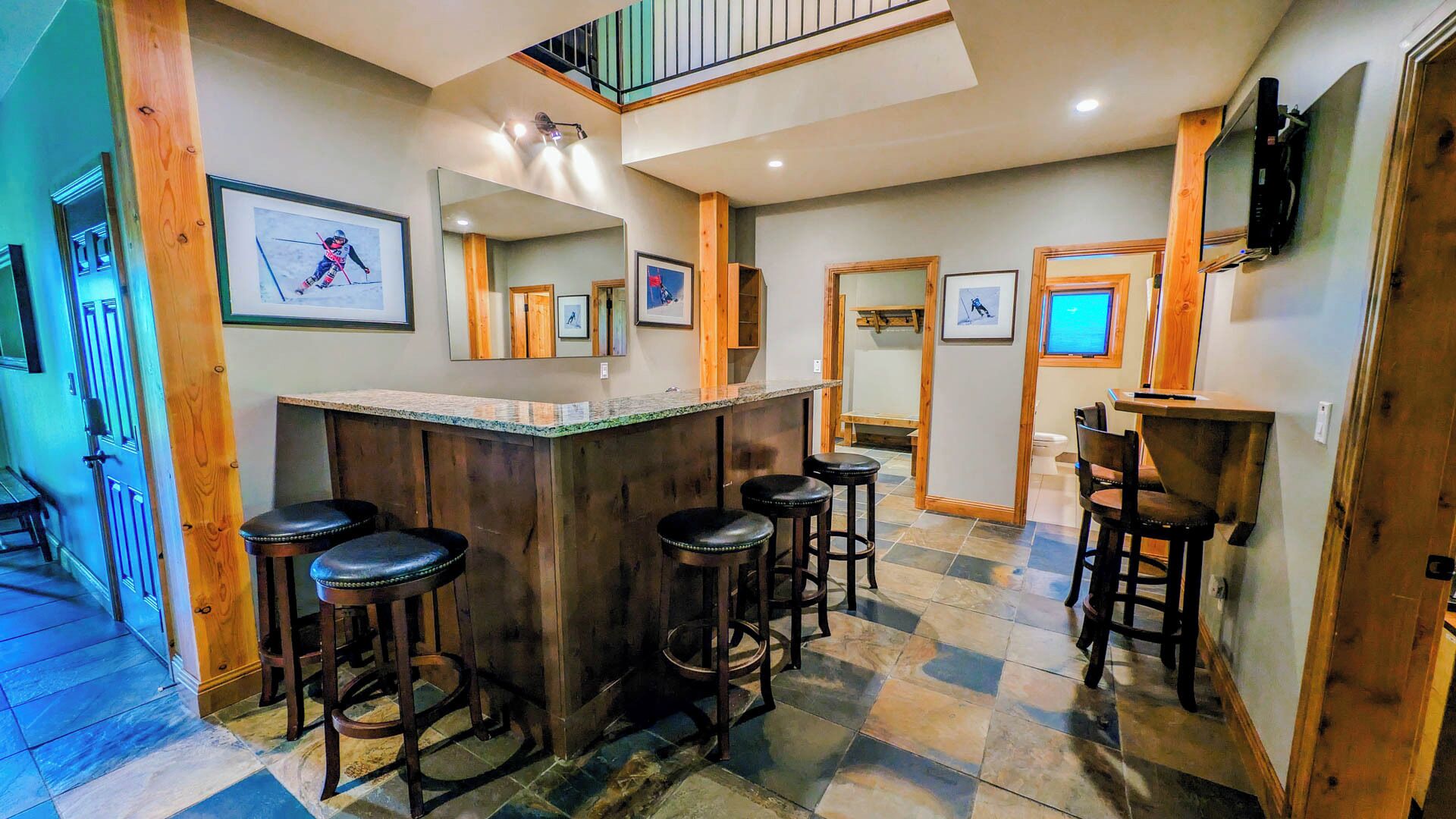 A bar area with stools, a counter, and framed pictures on the walls.