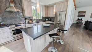 Una cocina moderna con una isla central, electrodomésticos de acero inoxidable y muebles de madera.