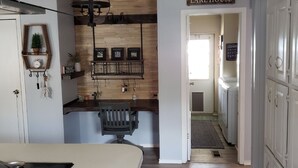 A kitchen with a wooden backsplash, a hanging light fixture, and a sign that reads "LAKE HOUSE".