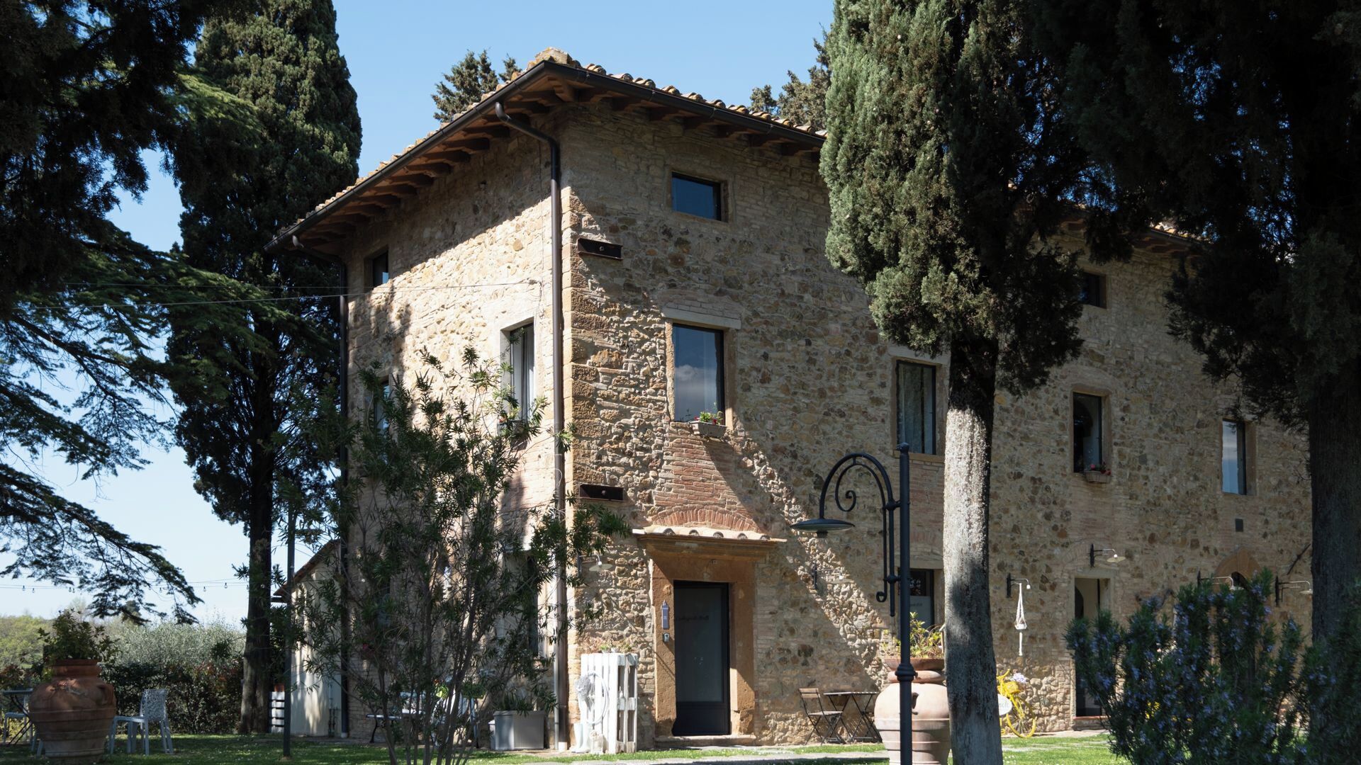 A stone building with a tiled roof, a door, and windows.