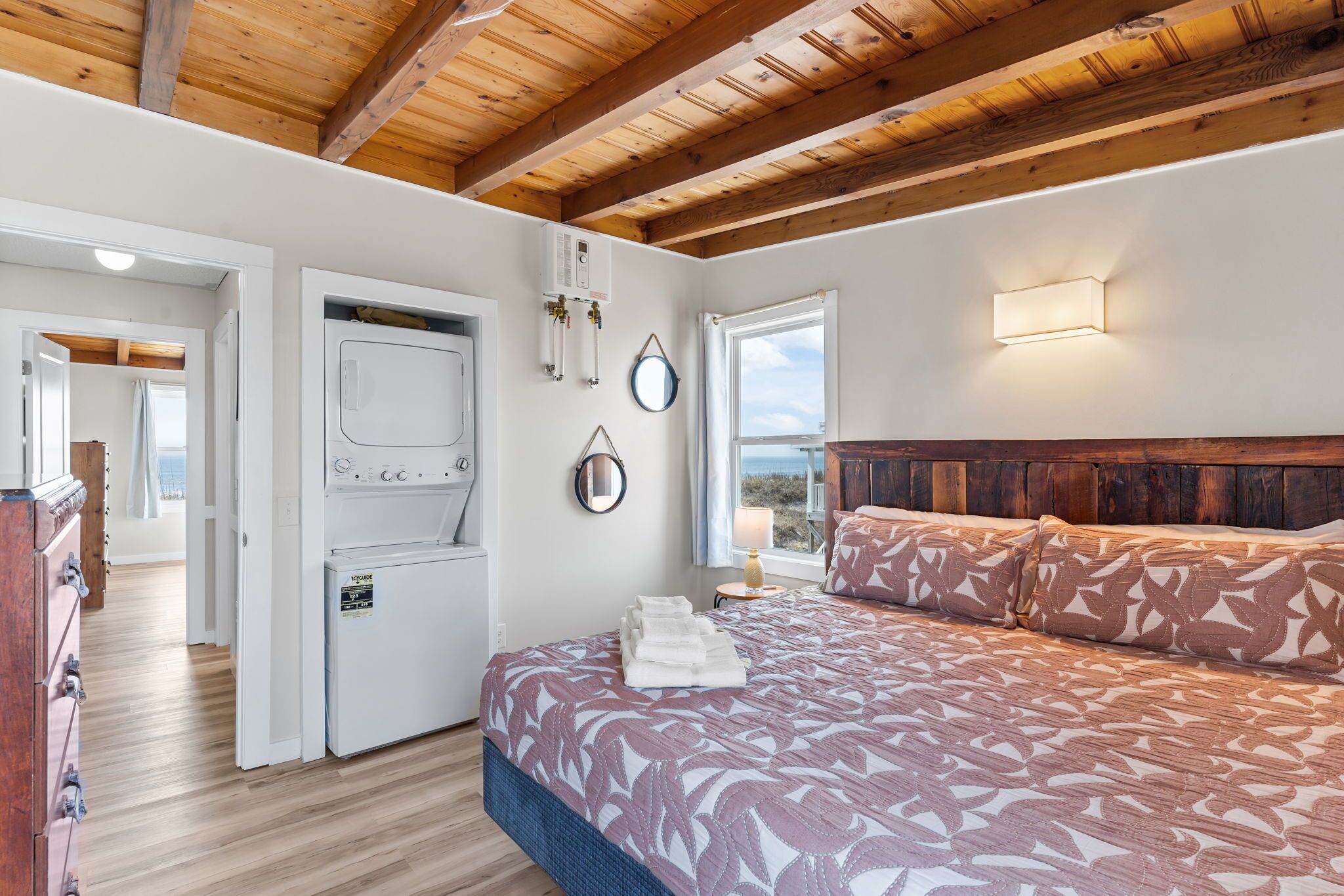 A bedroom with a bed, a heater, a window, and a view of the outdoors.