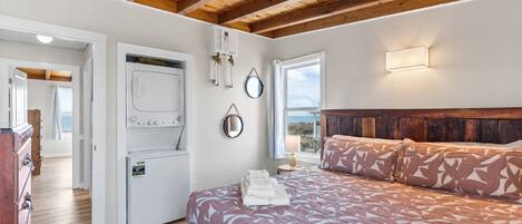 A bedroom with a bed, a heater, a window, and a view of the outdoors.