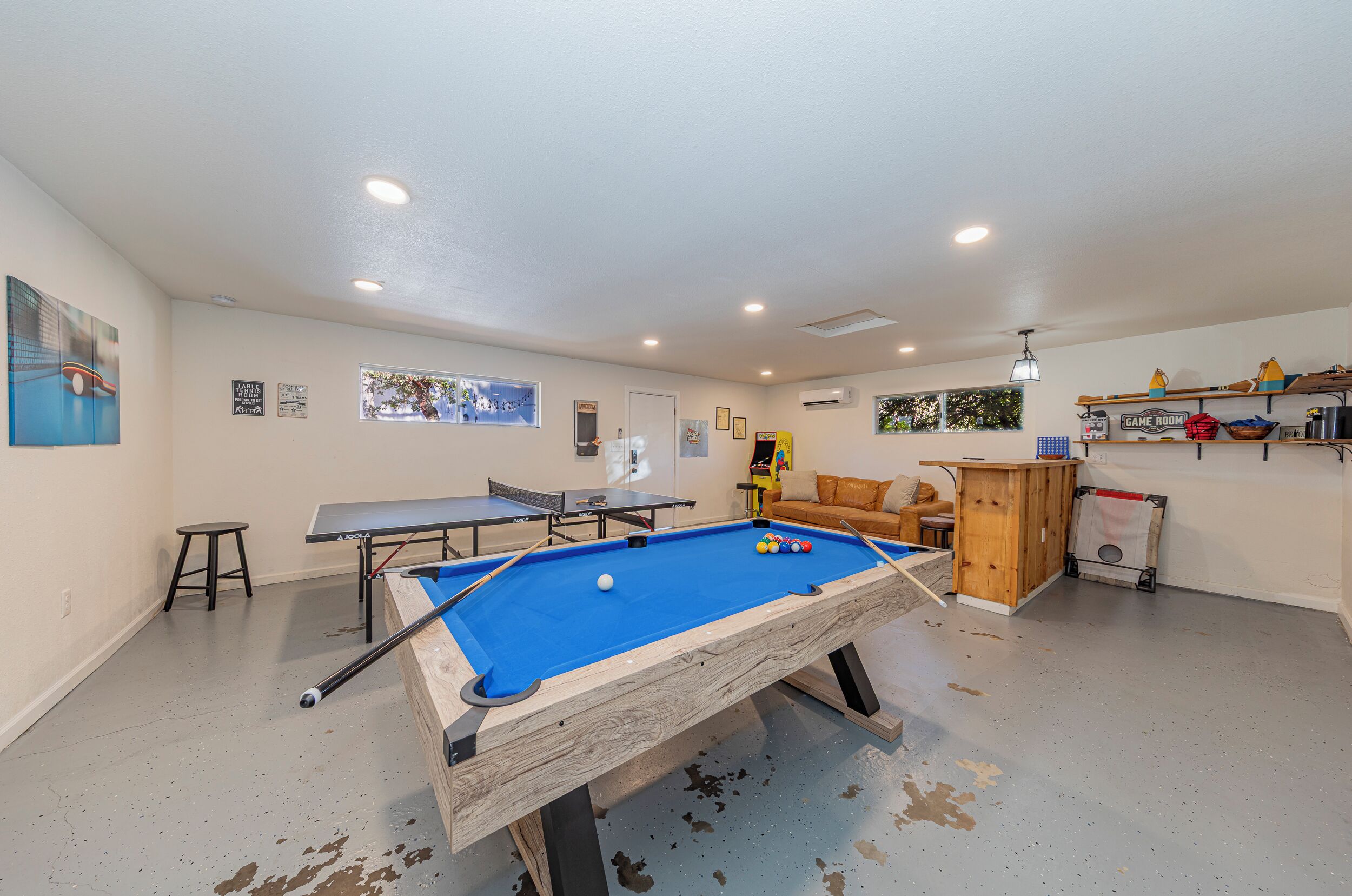 Ein Billardtisch mit blauer Spielvliesdecke, ein Tischtennistisch und ein weiterer Billardtisch.