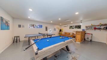 Ein Billardtisch mit blauer Spielvliesdecke, ein Tischtennistisch und ein weiterer Billardtisch.