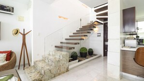 A modern interior with a staircase, a dining area, and a kitchen. - Casa Caracol (Bucerías)