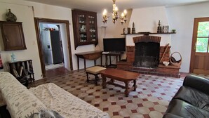 Un salon avec une cheminée, un canapé, une table et un téléviseur.