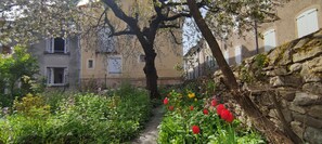 A narrow alley with a stone wall on one side and a building with windows on the other. - Large 200 m² house with a garden, terraces, and a courtyard. Florac Center. (Florac-Trois-Rivières)
