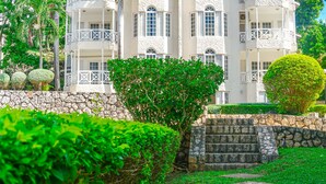A multi-story building with balconies, stone steps, and lush greenery. - Mira Bay Apartments (Montego Bay)