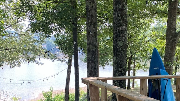 Una terraza de madera con un sendero de piedra que lleva a un lago.